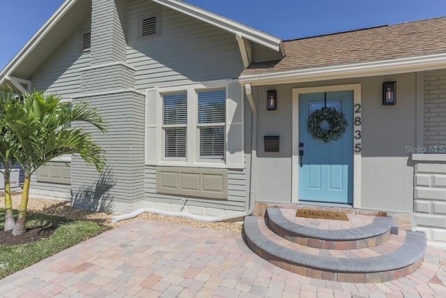 entrance to property with a shingled roof