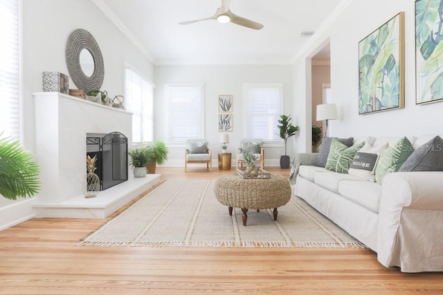 living room with visible vents, wood finished floors, a ceiling fan, and ornamental molding