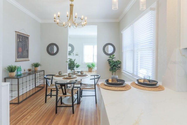 dining area with a notable chandelier, plenty of natural light, wood finished floors, and ornamental molding