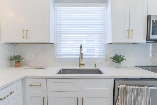 kitchen with dishwashing machine, a sink, white cabinetry, stainless steel microwave, and tasteful backsplash