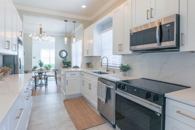 kitchen with a notable chandelier, ornamental molding, a sink, backsplash, and appliances with stainless steel finishes