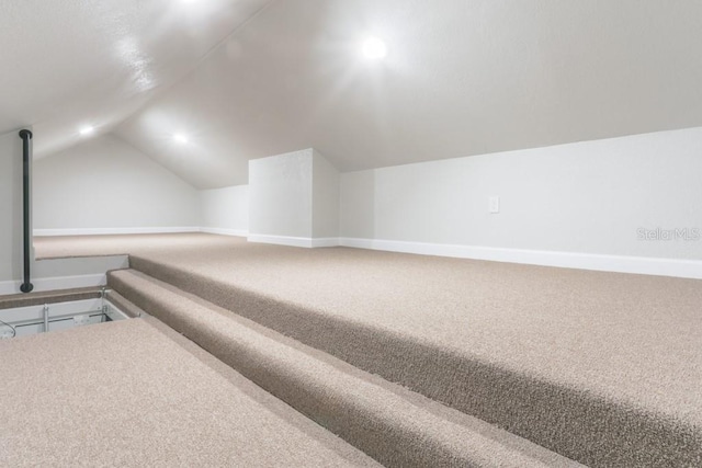 bonus room with lofted ceiling, carpet flooring, and baseboards