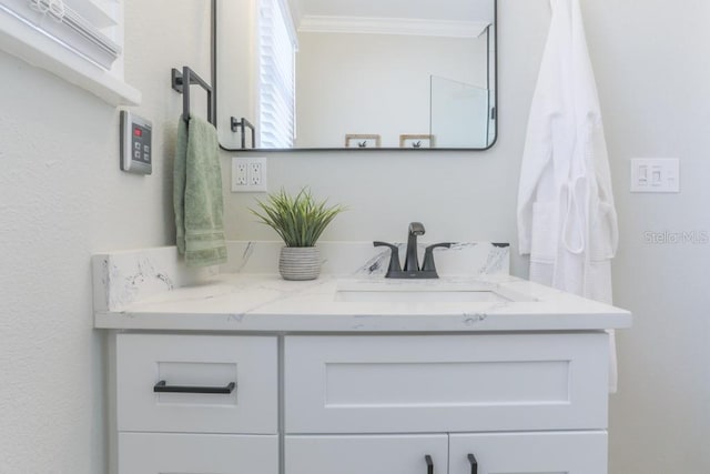 bathroom with ornamental molding and vanity