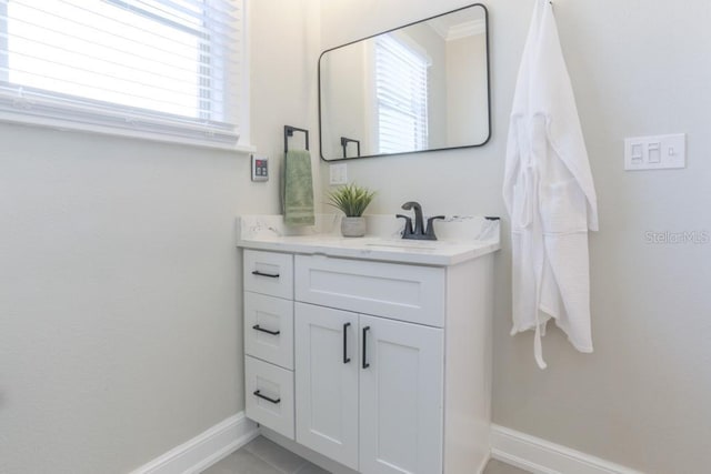 bathroom featuring vanity, plenty of natural light, and baseboards