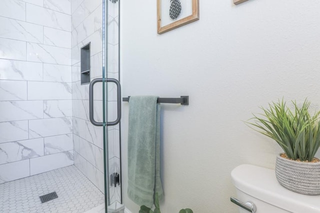 bathroom with toilet and a stall shower