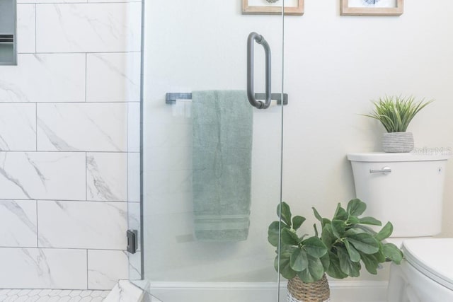 full bath featuring a shower stall and toilet