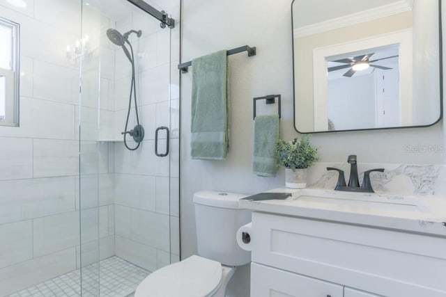 full bathroom featuring crown molding, toilet, a stall shower, vanity, and a ceiling fan