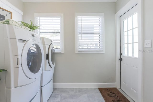 laundry area featuring light tile patterned floors, baseboards, separate washer and dryer, and laundry area