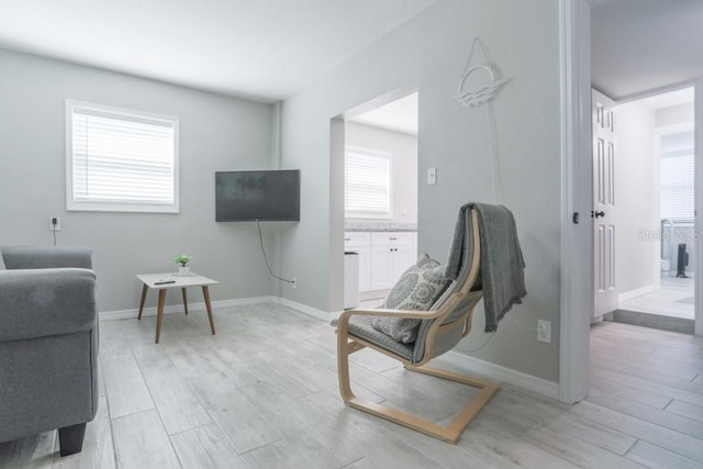 living area with baseboards and light wood-style floors