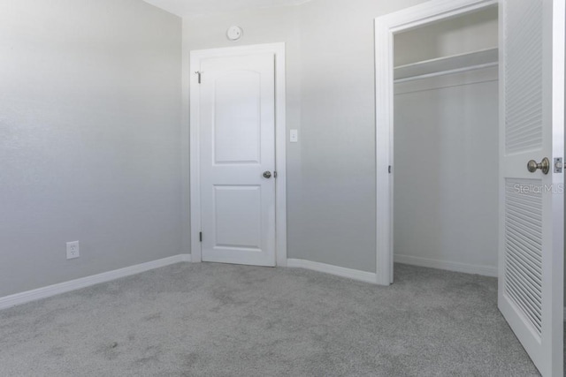 unfurnished bedroom with a closet, baseboards, and carpet