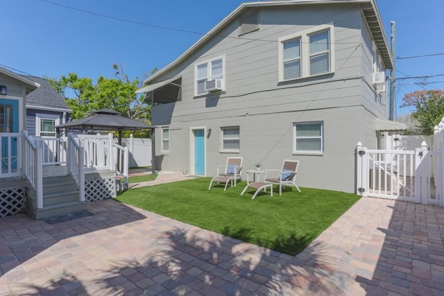 rear view of property with fence, a gazebo, a yard, a patio, and a gate