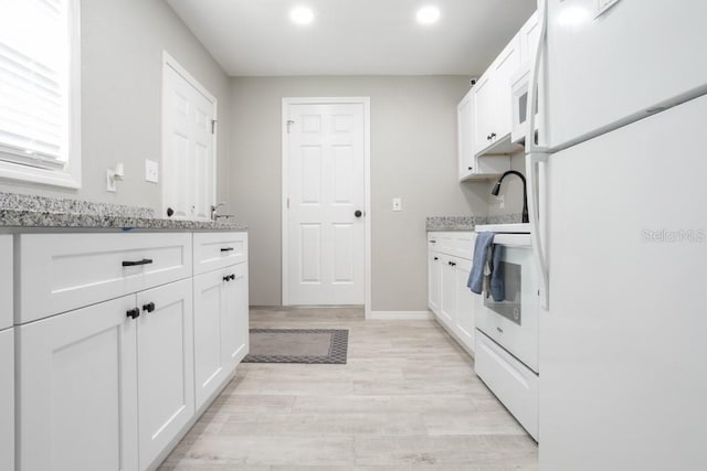 kitchen featuring light wood finished floors, white appliances, and white cabinetry