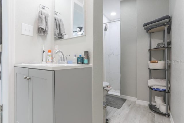 bathroom with curtained shower, wood finished floors, vanity, and baseboards