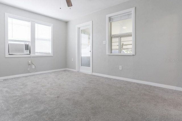 carpeted spare room featuring cooling unit, baseboards, and a ceiling fan