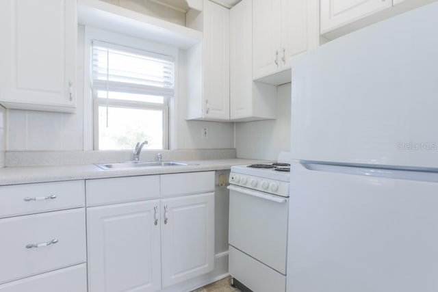 kitchen featuring a sink, white appliances, white cabinets, and light countertops