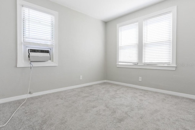 unfurnished room with cooling unit, carpet, and baseboards