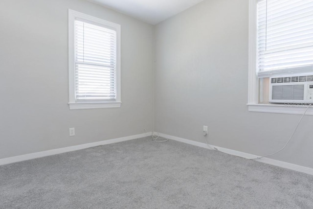 empty room with baseboards, carpet floors, and cooling unit