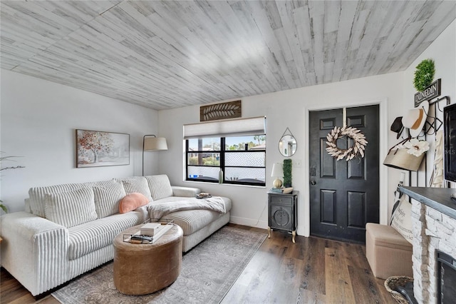 living room with a fireplace, baseboards, and wood finished floors