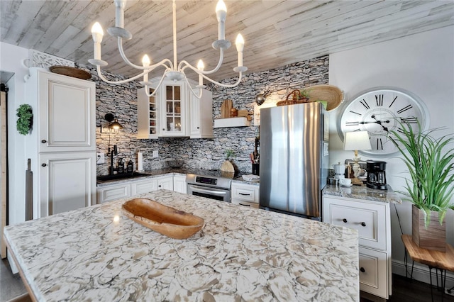 kitchen with light stone counters, freestanding refrigerator, wall oven, white cabinetry, and wooden ceiling