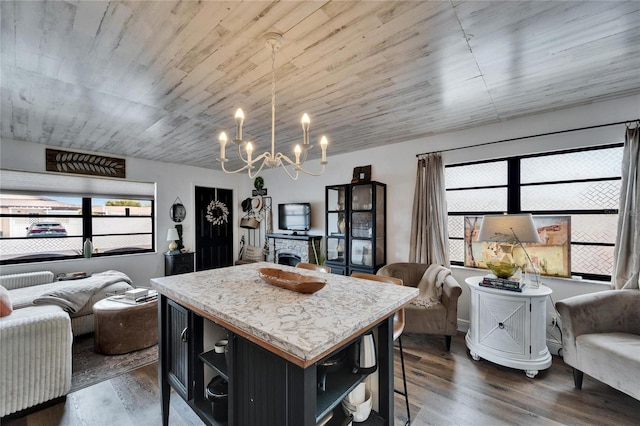 kitchen with dark cabinets, dark wood-style floors, a breakfast bar area, and open floor plan