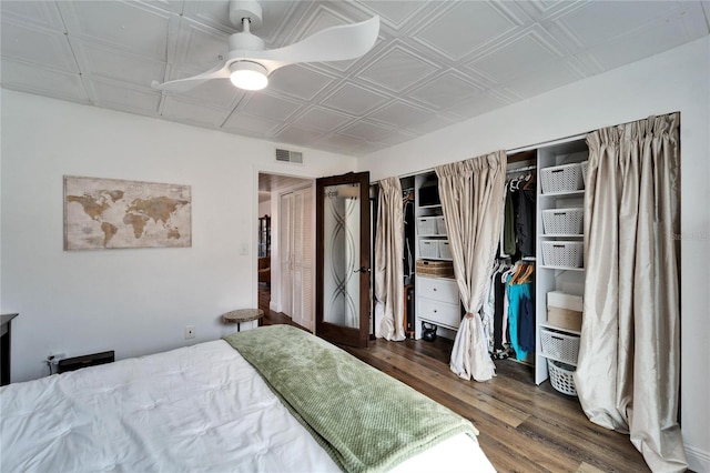 bedroom with visible vents, an ornate ceiling, a ceiling fan, and wood finished floors