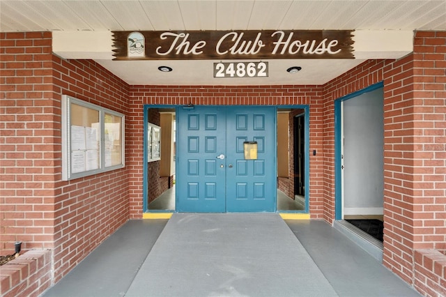 view of exterior entry featuring brick siding