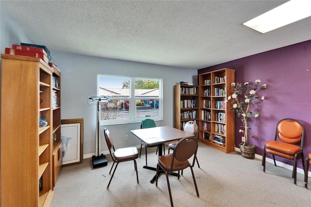 dining area featuring baseboards, carpet floors, and a textured ceiling