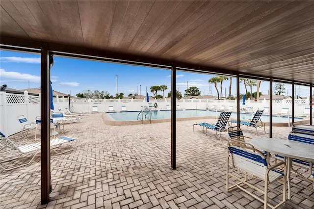 view of patio / terrace with outdoor dining area, a community pool, and a fenced backyard