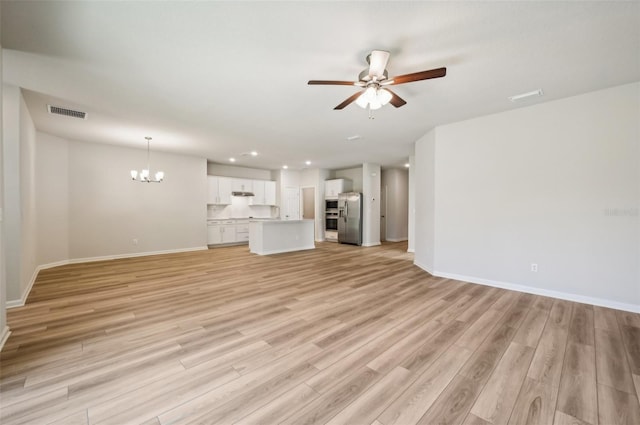 unfurnished living room with visible vents, baseboards, recessed lighting, ceiling fan with notable chandelier, and light wood-style flooring