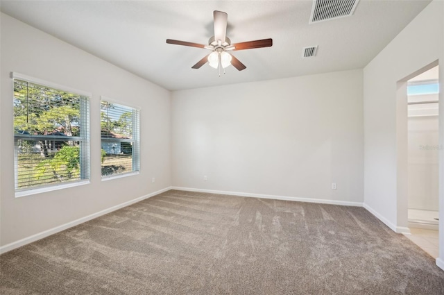 unfurnished room with visible vents, carpet floors, baseboards, and ceiling fan