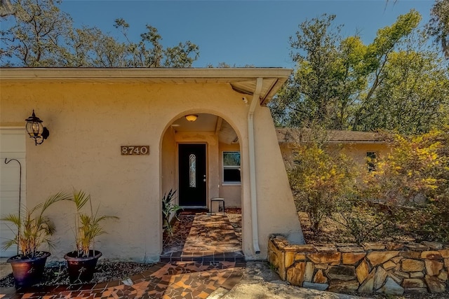 entrance to property featuring stucco siding