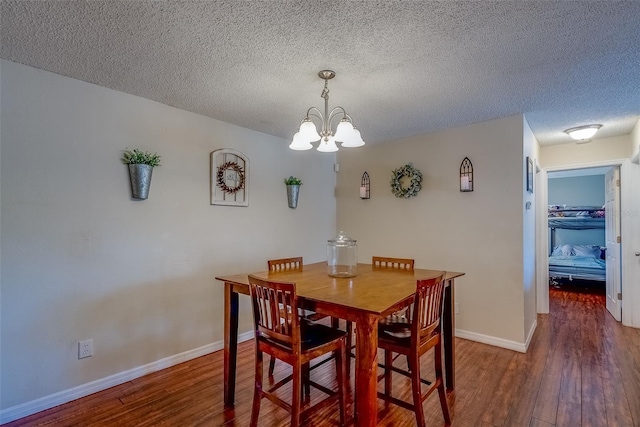 dining area with baseboards, a notable chandelier, wood finished floors, and a textured ceiling