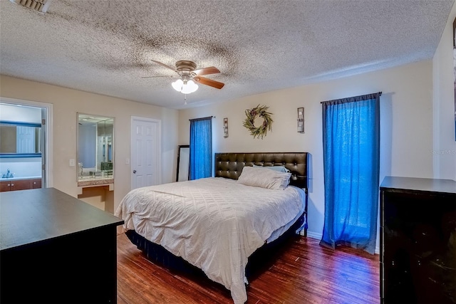 bedroom with visible vents, connected bathroom, dark wood finished floors, a textured ceiling, and a ceiling fan