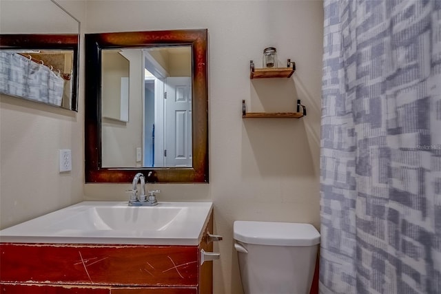 bathroom featuring curtained shower, toilet, and vanity