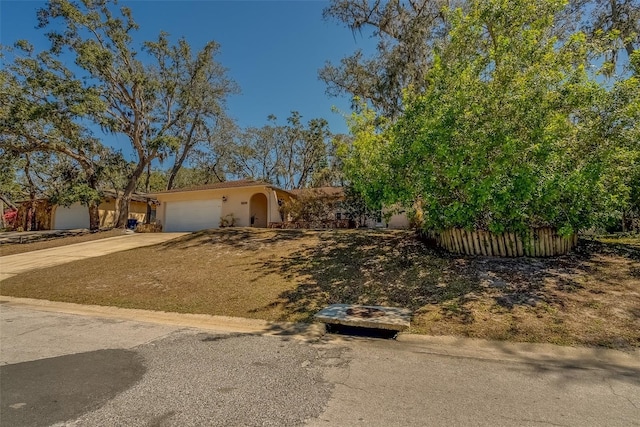 view of front facade featuring stucco siding, an attached garage, and concrete driveway