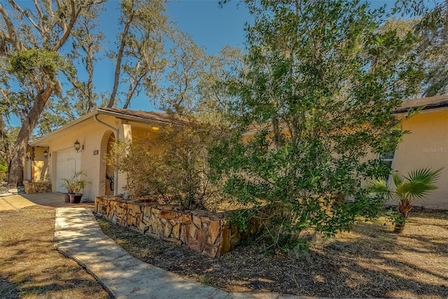 view of front of property featuring an attached garage, driveway, and stucco siding