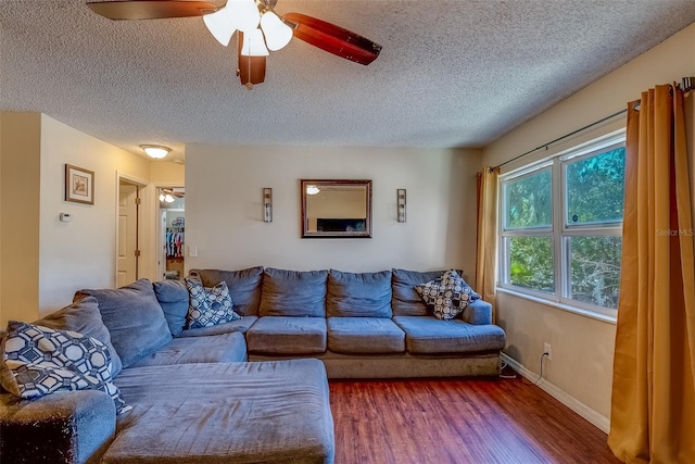 living area featuring a ceiling fan, wood finished floors, baseboards, and a textured ceiling
