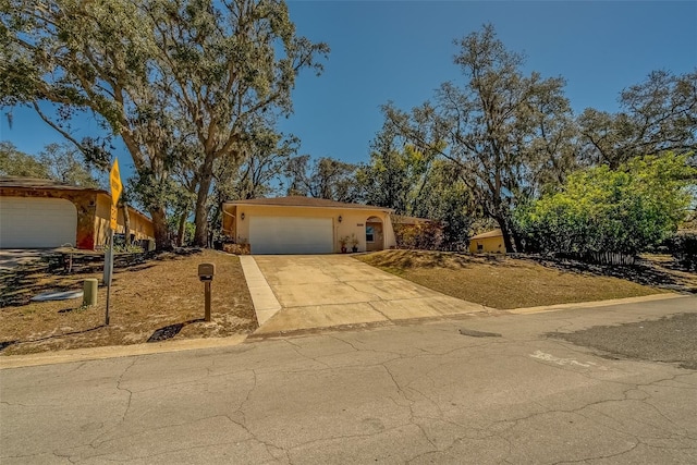 view of front facade with concrete driveway, a garage, and stucco siding