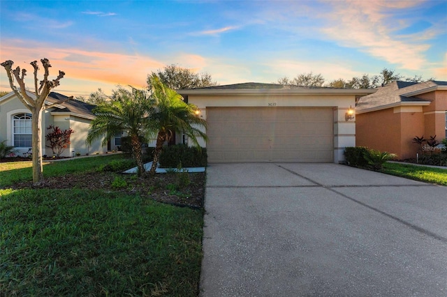 single story home featuring stucco siding, a front yard, an attached garage, and driveway