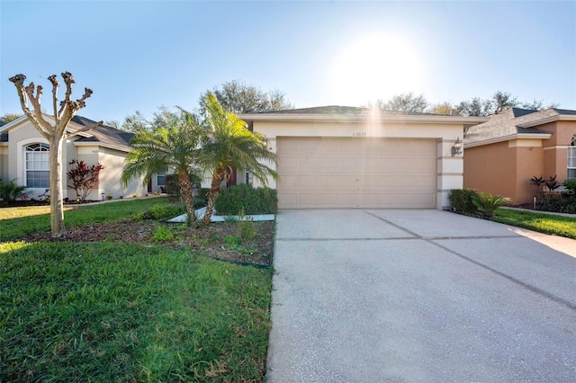 view of front of house featuring stucco siding, a front lawn, a garage, and driveway