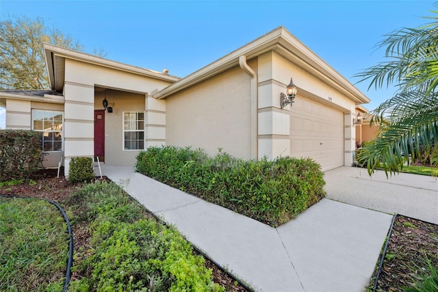 view of front of property with stucco siding, driveway, and a garage