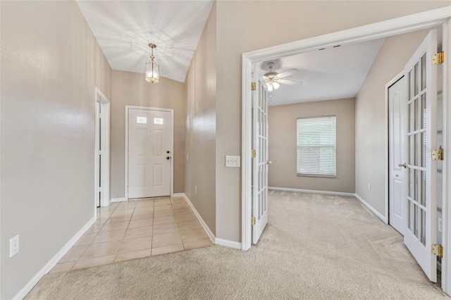 tiled entryway with french doors, baseboards, carpet, and a ceiling fan