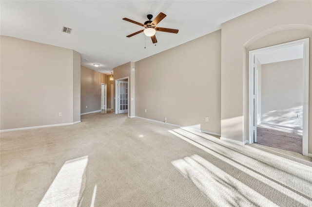 carpeted empty room with a ceiling fan, visible vents, and baseboards