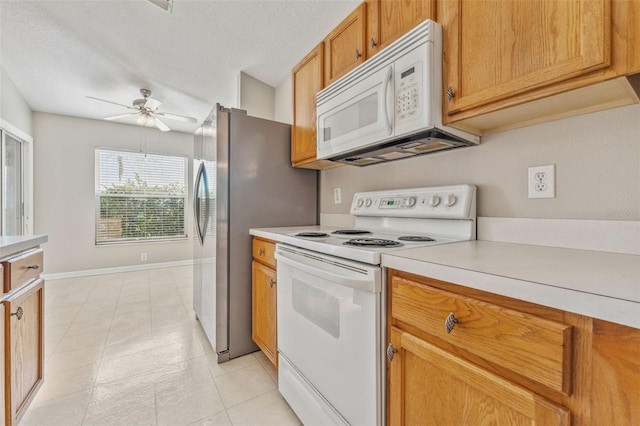 kitchen featuring baseboards, light countertops, white appliances, a textured ceiling, and a ceiling fan