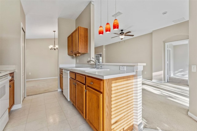 kitchen featuring visible vents, light carpet, brown cabinetry, white appliances, and a sink