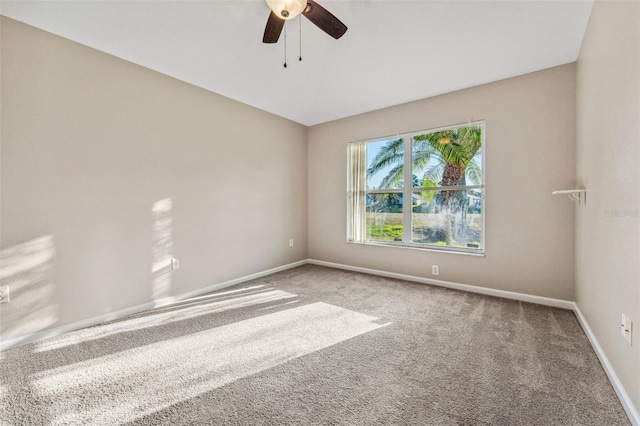 unfurnished room with carpet flooring, a ceiling fan, and baseboards