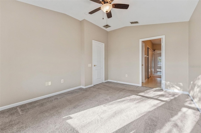 unfurnished bedroom featuring light carpet, visible vents, baseboards, and vaulted ceiling