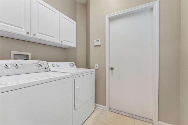 laundry room with light tile patterned flooring, cabinet space, baseboards, and washing machine and clothes dryer