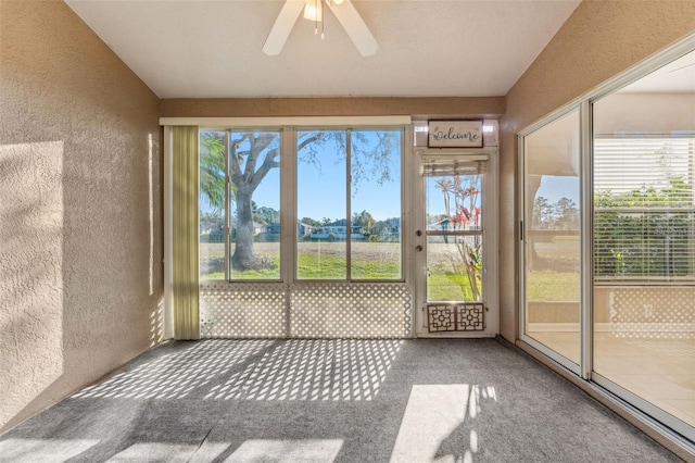 unfurnished sunroom with a ceiling fan