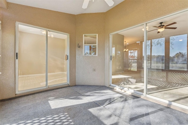 unfurnished sunroom featuring a ceiling fan